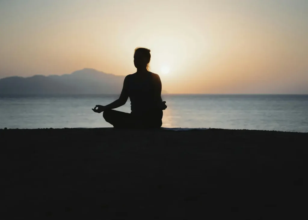 Mujer meditando junto al mar