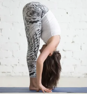 Mujer joven practicando la postura de yoga uttanasana