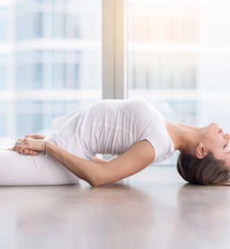 Mujer practicando yoga restaurativo