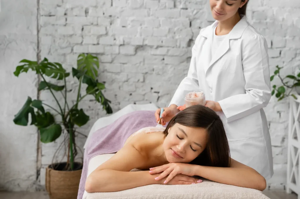 Mujer relajada durante una sesión de acupuntura realizada por una terapeuta profesional en un centro de bienestar